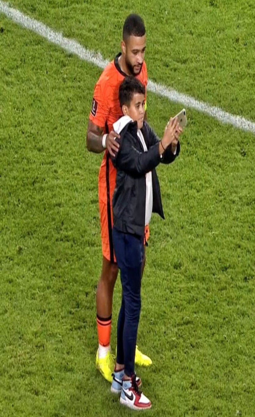 Un niño salta al césped para hacerse un selfi con Depay